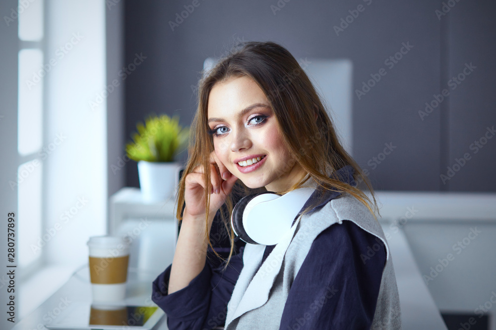 Focused attentive woman in headphones sits at desk with laptop, Focused attentive woman in headphones sits at desk with laptop,