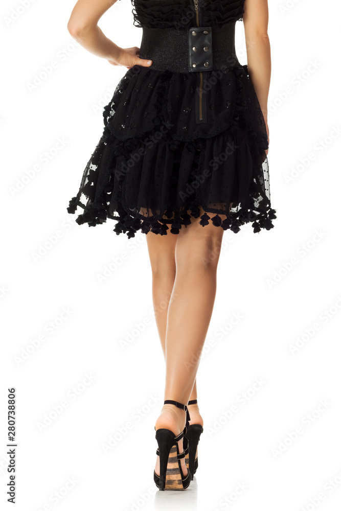 Woman in black dress standing in high heels shoes isolated on white background. Woman in black dress standing in high heels shoes isolated on white background.