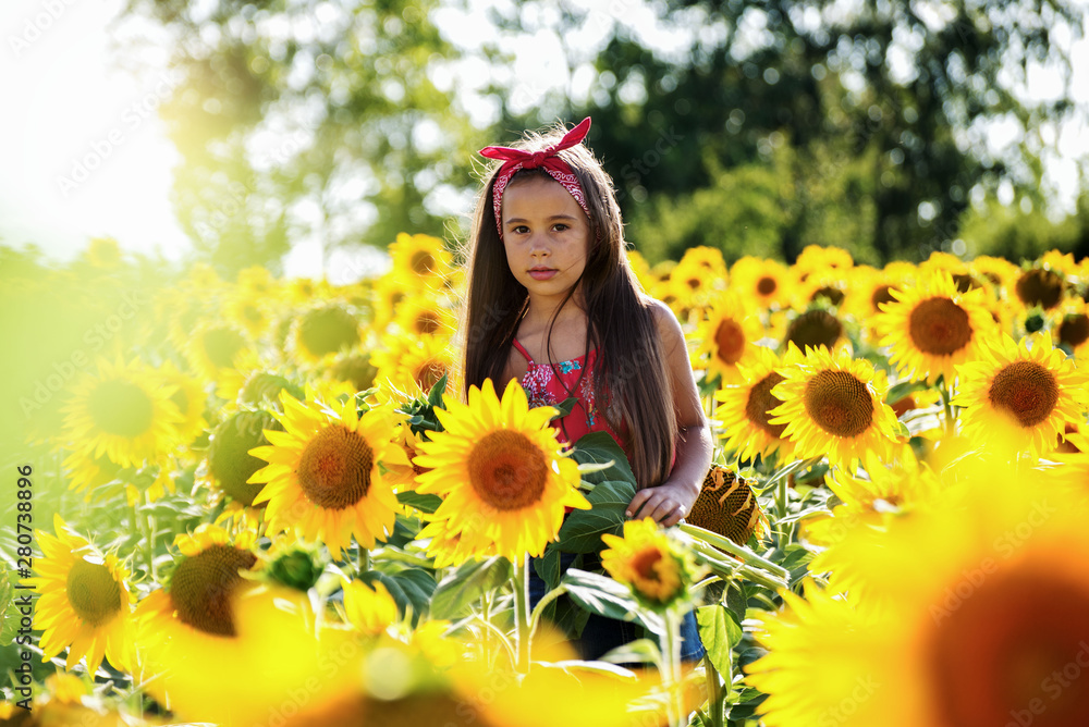 Child girl in yellow garden of sunflowers Child girl in yellow garden of sunflowers