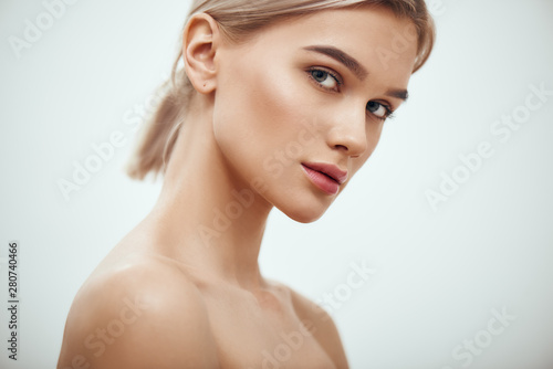 Feeling beautiful. Gorgeous young blonde woman with perfect skin looking at camera while standing against grey background