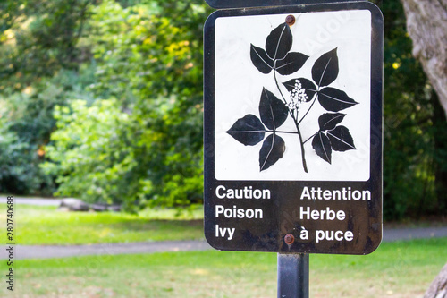 A bilingual sign warns park-goers to watch for poison ivy