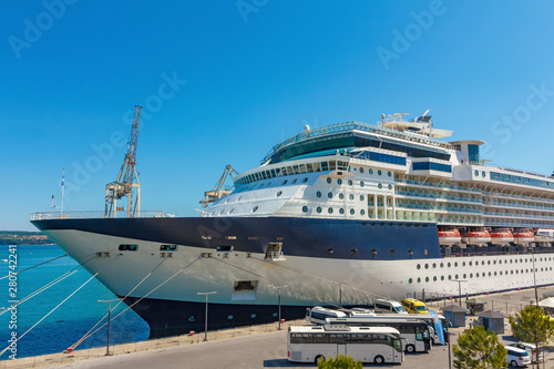 A large luxury cruise liner moored in the port of the Adriatic Sea, is waiting for passengers. There are four orange lifeboats abroad of a cruise ship in Koper, Slovenia. photo