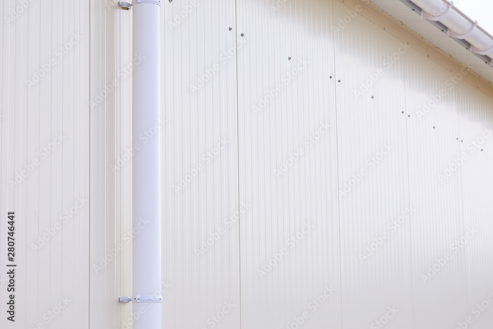 White plastic rain guttering system. Guttering drainage pipe exterior. Background of sandwich panel White plastic rain guttering system. Guttering drainage pipe exterior. Background of sandwich panel