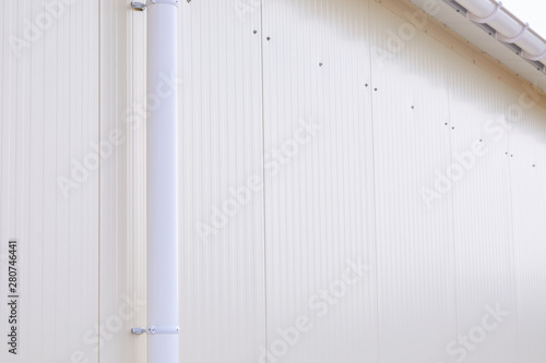 White plastic rain guttering system. Guttering drainage pipe exterior. Background of sandwich panel  © Liudmila