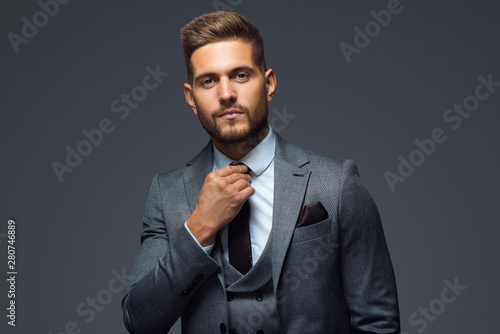 Stylish young man in suit and tie. Business style. Fashionable image. Office worker. Sexy man standing and looking at the camera