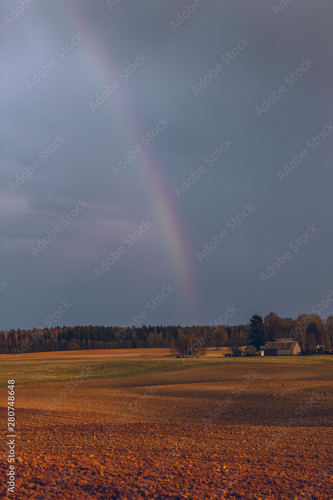 Almost invisible rainbow in the countryside