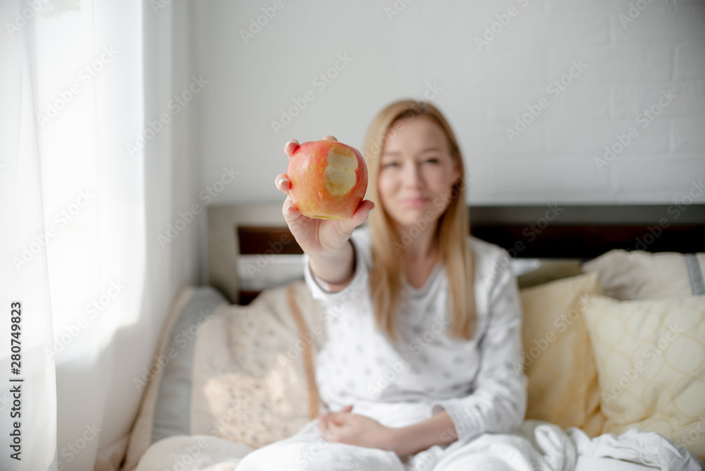 Blonde Girl bites red apple. Health care and teeth care concept. Horizontal copyspace Blonde Girl bites red apple. Health care and teeth care concept. Horizontal copyspace