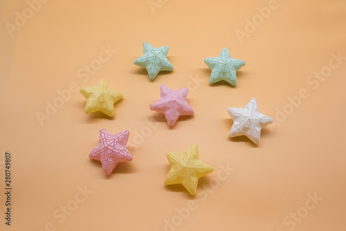 Beautiful colorful toy stars neatly placed on a warm background, festive stars background