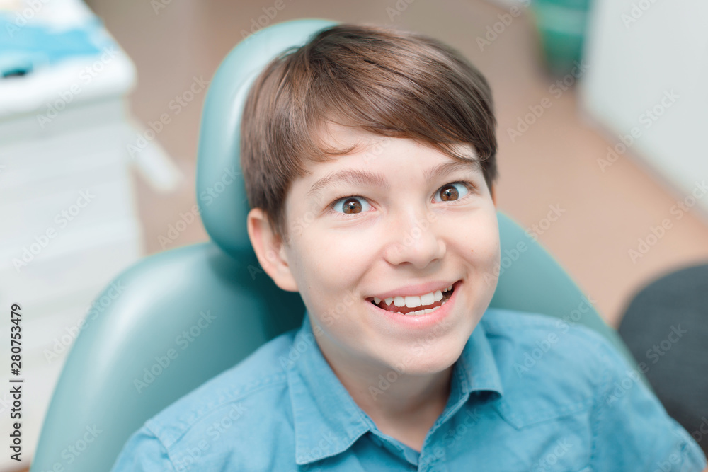 Little boy in dental chair. Smiling and satisfied patient at dentist's office after treatment. Healthy teeth, dental care concept. Little boy in dental chair. Smiling and satisfied patient at dentist's office after treatment. Healthy teeth, dental care concept.