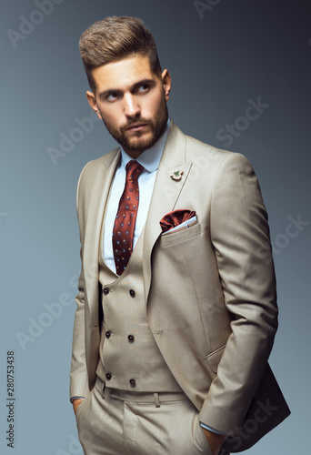 Stylish young man in suit and tie. Business style. Fashionable image. Office worker. Sexy man standing and looking at the camera