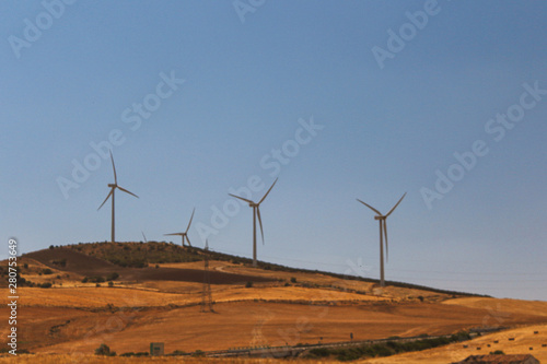 wind power plant windmill energy electricity on the yellow hills soft selective focus