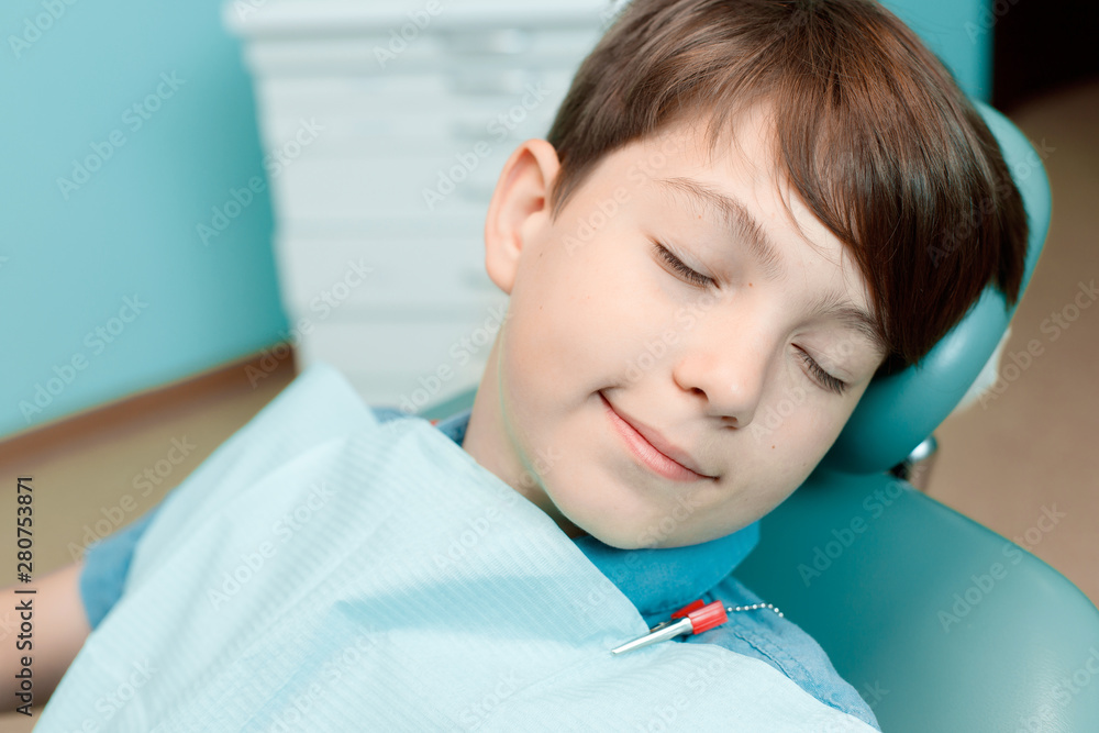 Patient in dental chair. Little boy having dental treatment at dentist's office. Healthy teeth, dental care concept. Patient in dental chair. Little boy having dental treatment at dentist's office. Healthy teeth, dental care concept.