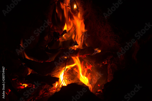 Mountain summer. Bonfire in night. Black background