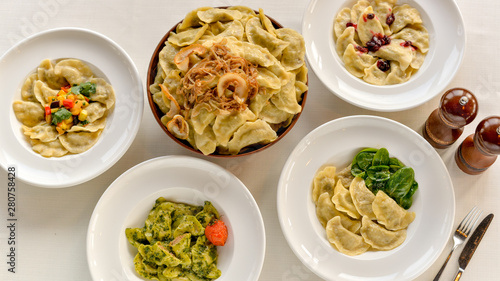 many different vareniki in plates on the table