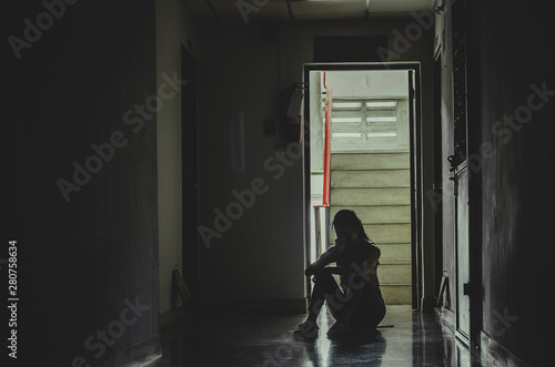 Wallpaper Mural Silhouette of girl sitting alone in the dark,Sad and Serious women sitting hug his knee alone of old condo, Domestic violence, family problems, The concept of depression and suicide with copy space Torontodigital.ca