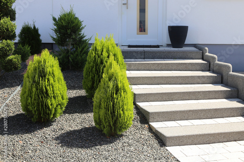 Neat and tidy front yard with solid block steps, decorative gravel and planting