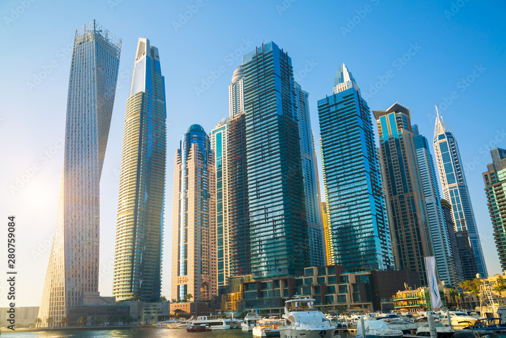 Dubai, UAE United Arabs Emirates. Dubai marina skyscrapers and yachts at sunset. Apartments, hotels and office buildings, modern residential development of UAE