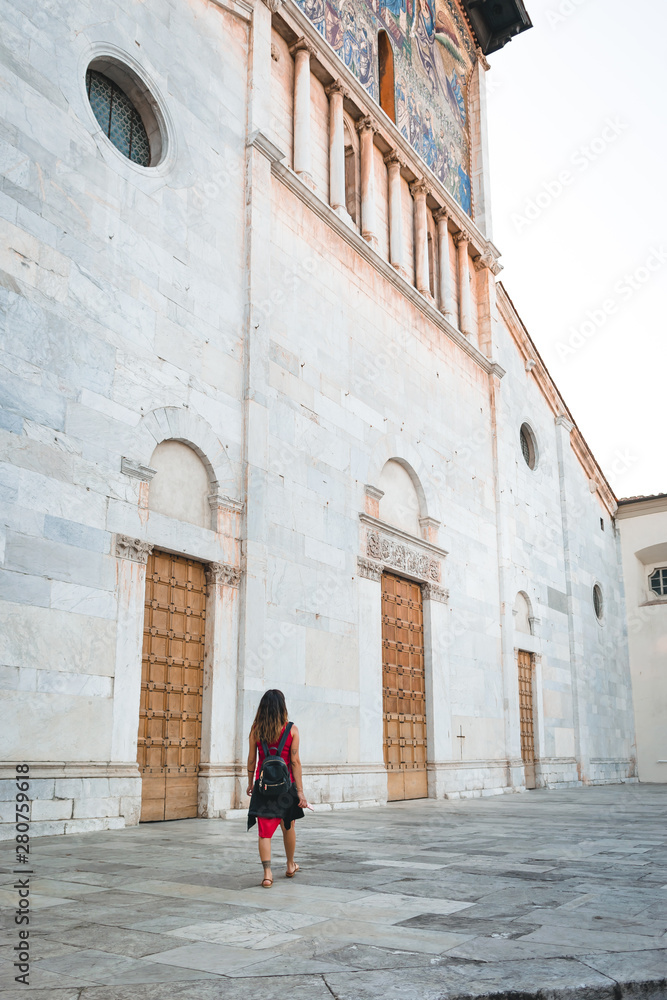 A girl walking in front of a church in Lucca