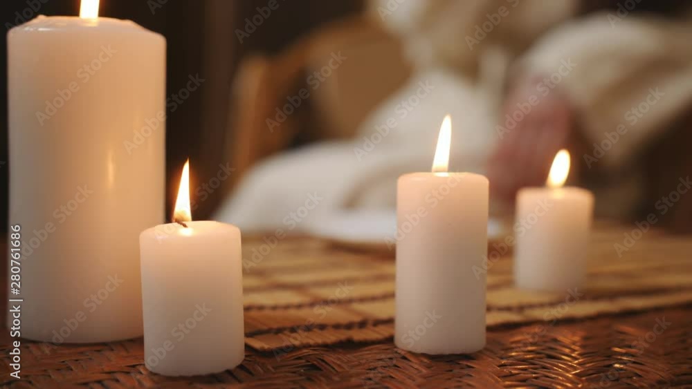 Burning candles in Spa salon close up, in the background out of focus woman in Bathrobe. Burning candles in Spa salon close up, in the background out of focus woman in Bathrobe.