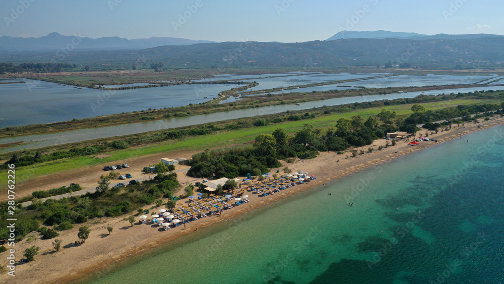 Aerial drone photo of iconic sandy beach of Divari (chrysi akti) with emerald sea near island of Sfaktiria in bay of Navarino, Messinia, Gialova, Peloponnese, Greece