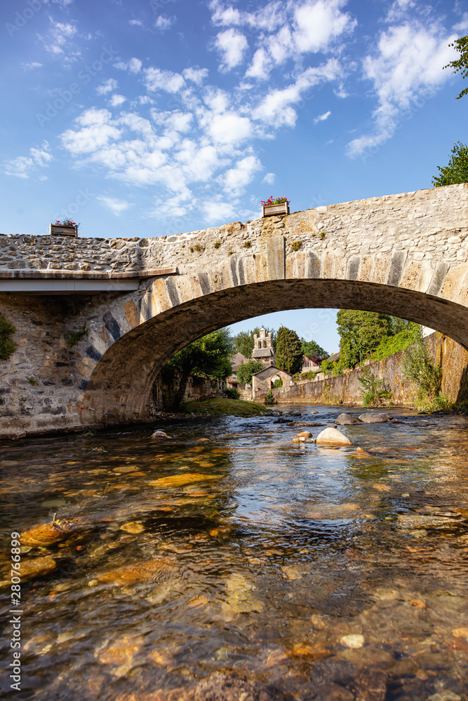 View of the river bridge and the village church Audressein in the department of Ariège, in the Pyrenees, Occitanie region, France
