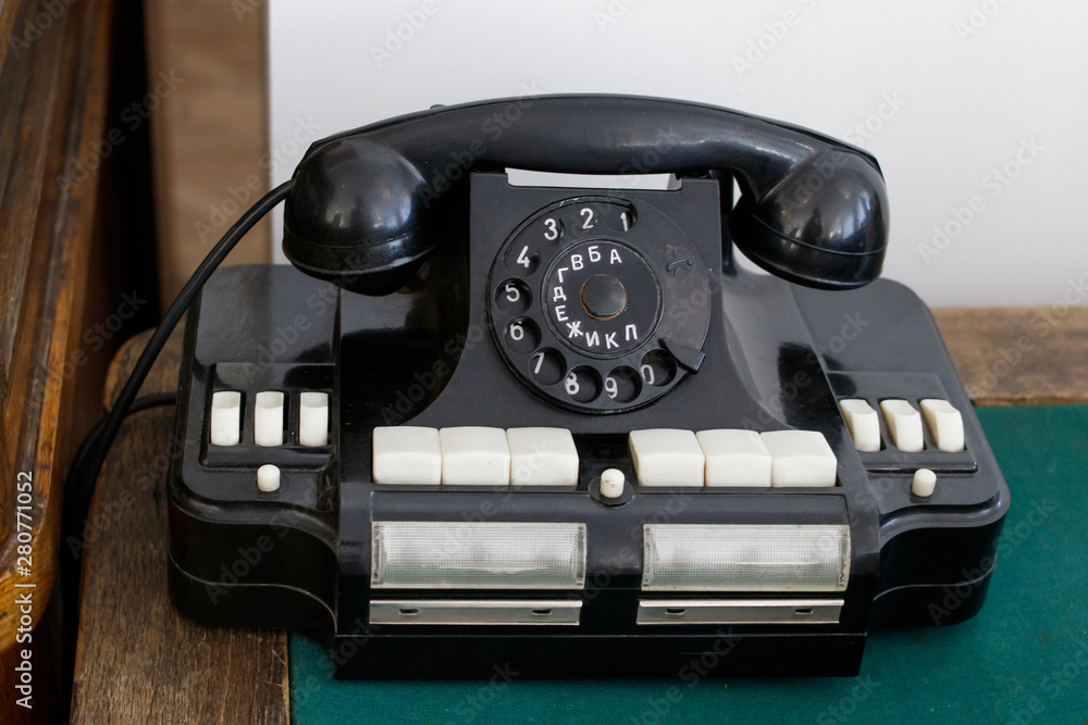 An old Soviet office telephone with Russian letters on a wooden table