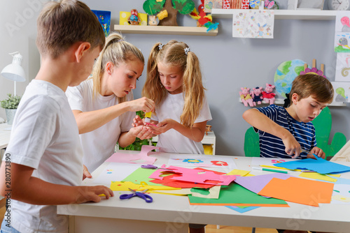 Mother or school teacher with children. Creative arts and crafts project at school or at home.