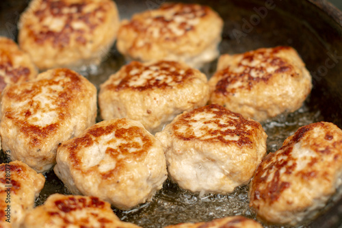 Tasty, fragrant healthy cutlets of chicken meat with spices are fried in a pan in oil.