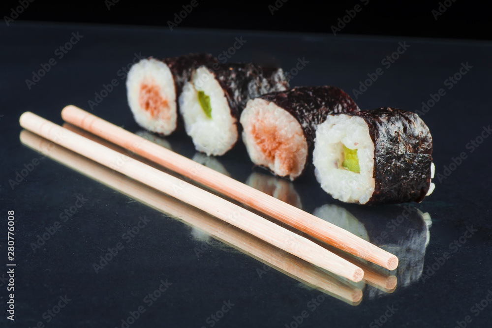 Sushi and chopsticks on a glass black background Sushi and chopsticks on a glass black background