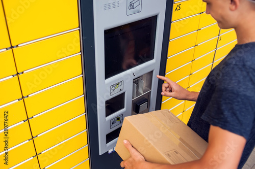 Client using automated self service post terminal machine or locker to deposit a parcel for storage