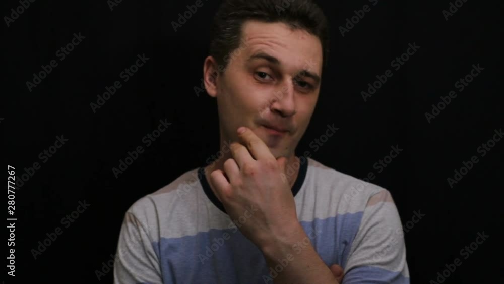 serene young handsome caucasian man shows his emotion close-up serene young handsome caucasian man shows his emotion close-up