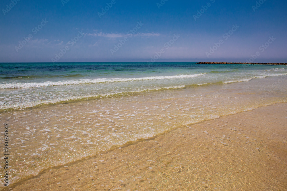 Fototapeta premium Soft blue ocean wave on sandy beach. Bottom. White sand on the beach with turquoise water in Djerba, Tunisia.