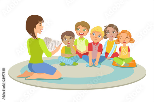 Group Of Small Kids Sitting Around The Teacher On The Floor Reading A Story