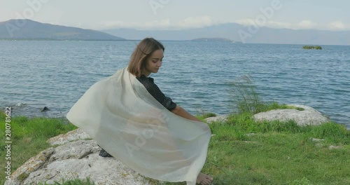 Girl stait on the pier, walking on the beach. Posing in front of the camera, Smiling, walking barefoot in the sand, the wind playing with a shawl photo