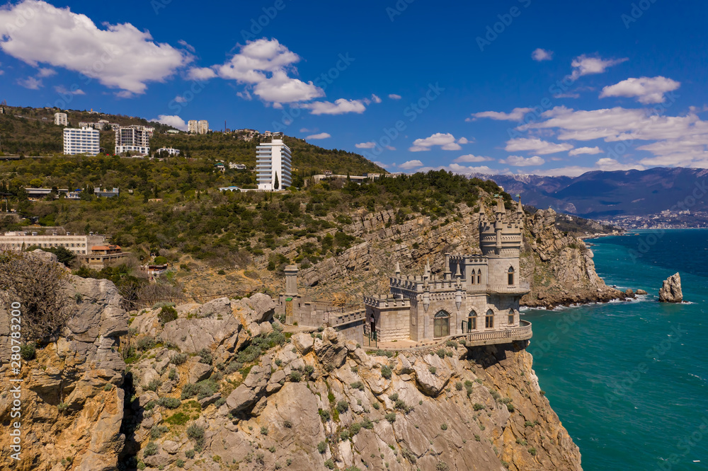Castle Swallow's Nest on a rock at Black Sea, Crimea. Castle is located in the urban area of Gaspra, Yalta. Aerial drone view