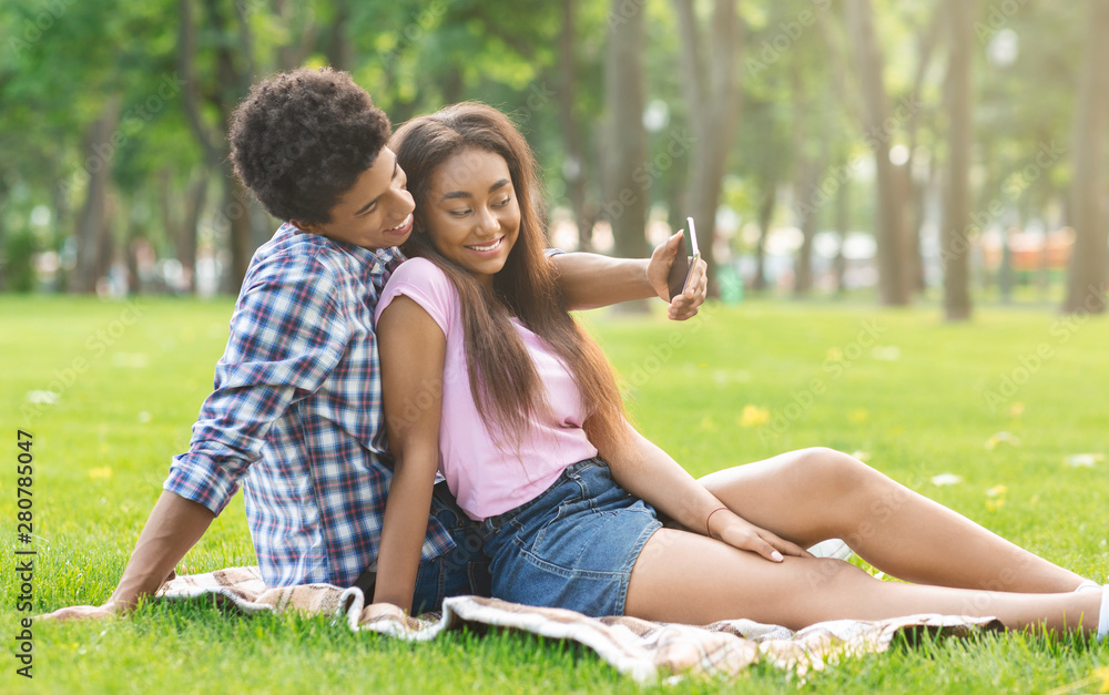 Romantic teenagers taking selfie on a date in park Romantic teenagers taking selfie on a date in park