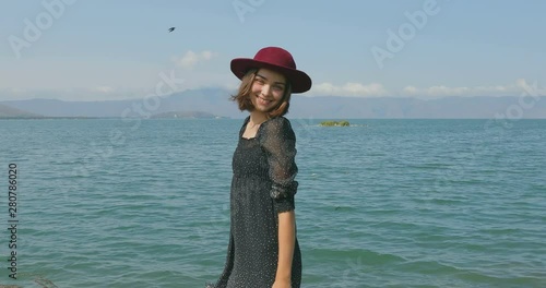 Girl stait on the pier, walking on the beach. Posing in front of the camera, Smiling, walking barefoot in the sand, the wind playing with a shawl photo