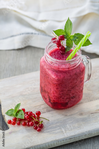 Photo of red currant smoothie in jar with straw on light background. Fresh organic Smoothie. Health or detox diet food concept. photo