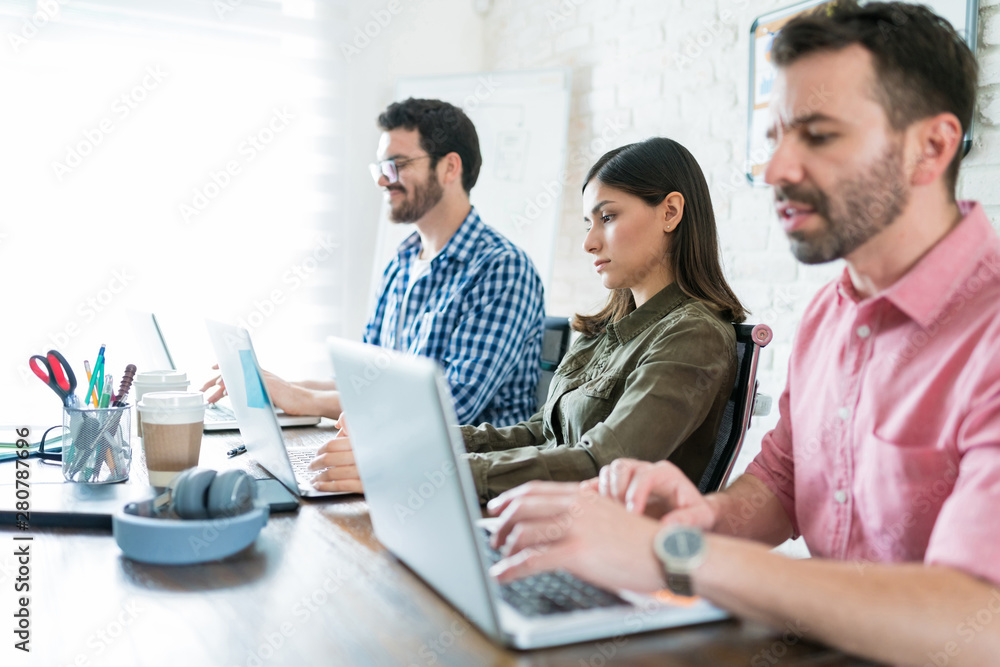 Professionals Using Laptops At Office