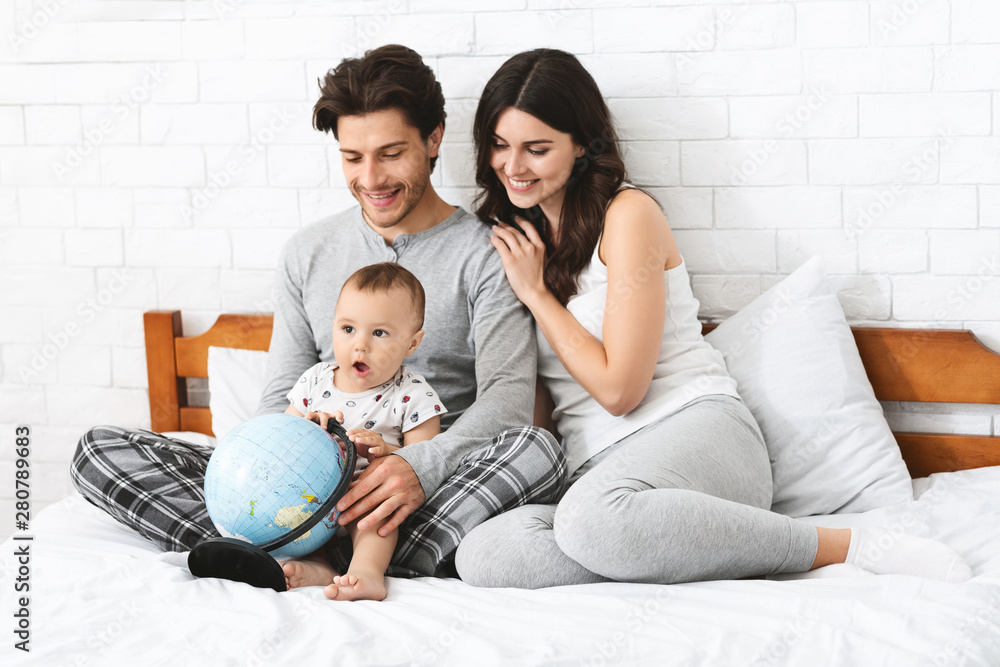 Happy family preparing to travel trip, learn for route on globe Happy family preparing to travel trip, learn for route on globe