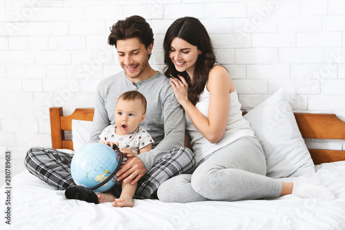 Happy family preparing to travel trip, learn for route on globe