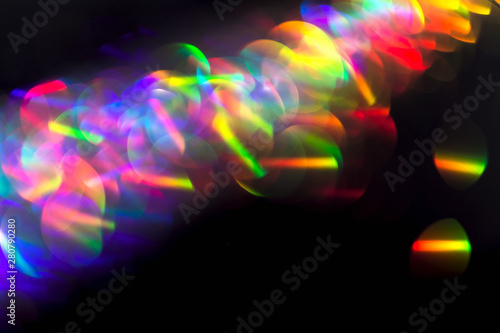 Multicolor beautiful bright neon lights flares and trails lines in motion on isolated black background. Bokeh lens flare glow. Festive backdrop