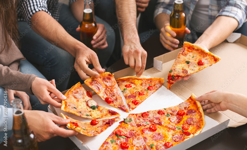 Group of friends sharing pizza together at home party