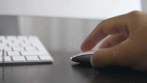 Closeup of a man in the office working at the computer holding a computer mouse