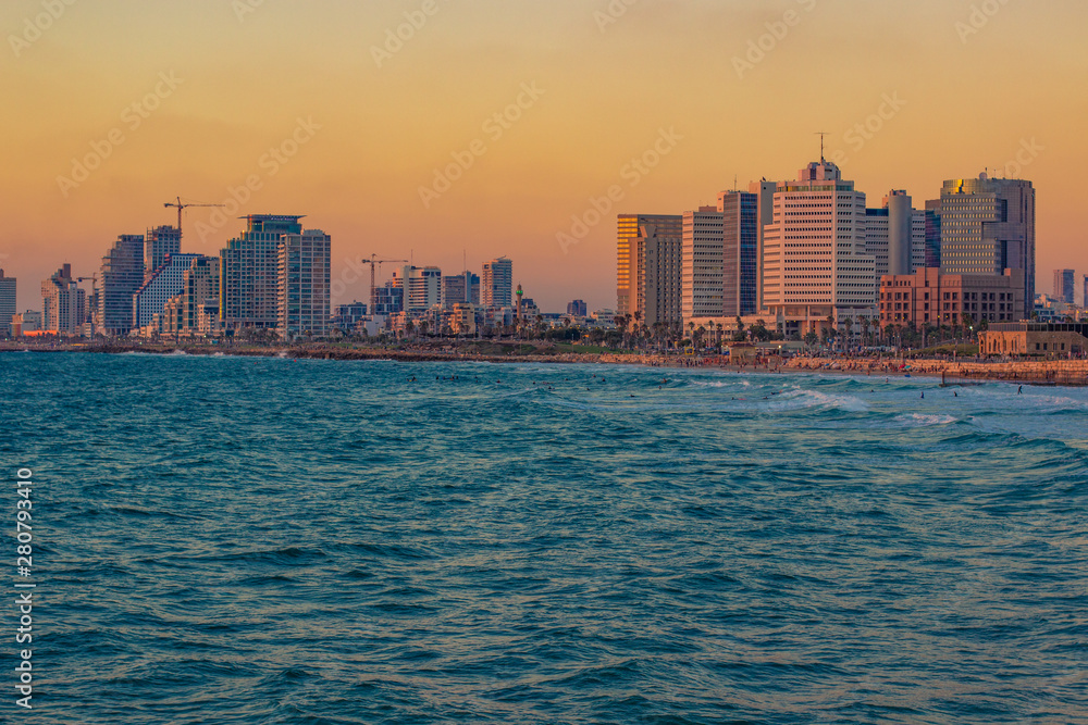 beautiful Tel Aviv Israeli capital city with skyscrapers buildings on Mediterranean sea wavy waterfront landmark and landscape photography in colorful sunset evening time