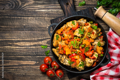 Chicken Stir fry with vegetables on wooden table.