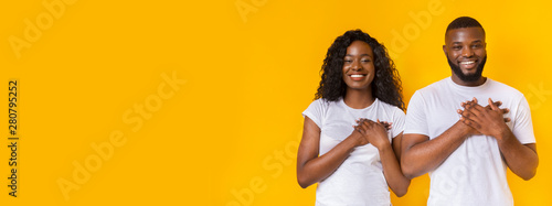 Εκτύπωση καμβά Smiling afro man and woman placing hands on their hearts
