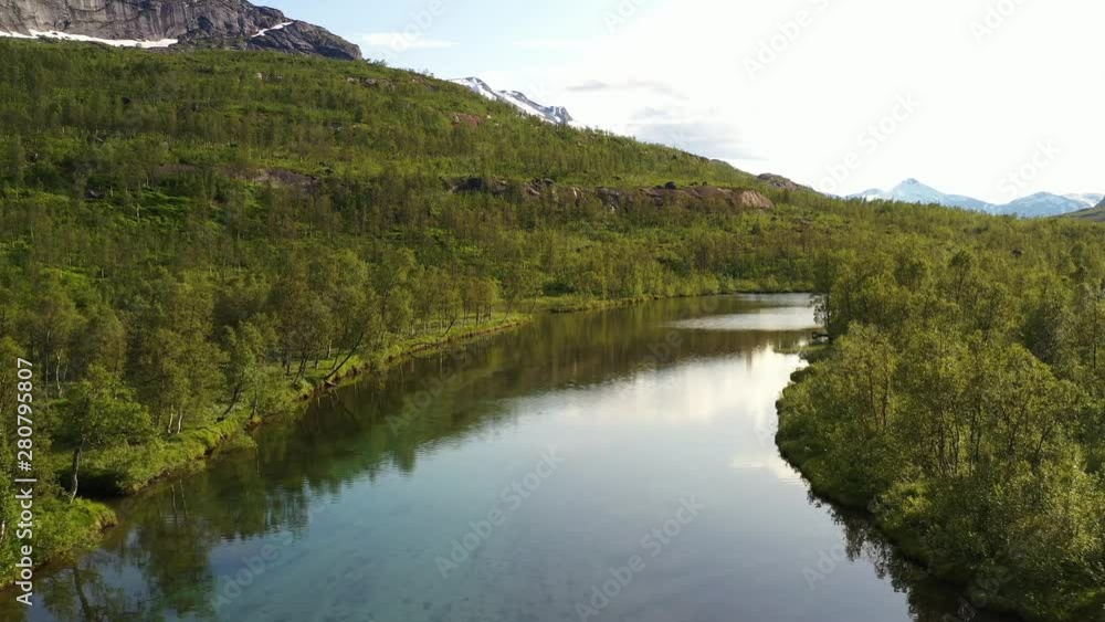 Beautiful slow flying forward drone shot over a calm river in high mountains on a sunny summer day Beautiful slow flying forward drone shot over a calm river in high mountains on a sunny summer day