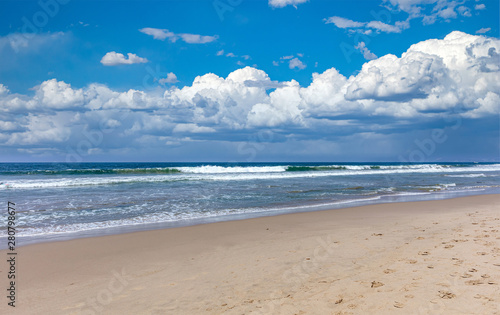 Fototapeta Naklejka Na Ścianę i Meble -  Sandy beach empty. Blue sky with clouds, blue sea