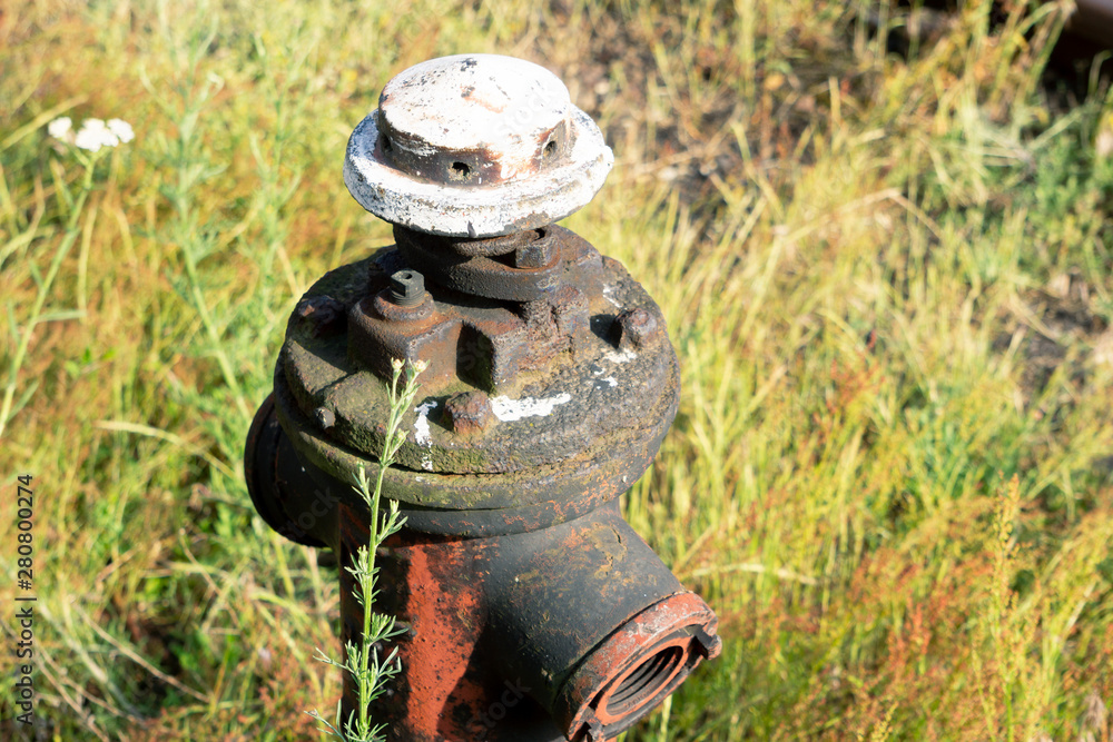 Stryi hydrant overgrown with grass. Water pipe for refueling the fire truck Stryi hydrant overgrown with grass. Water pipe for refueling the fire truck
